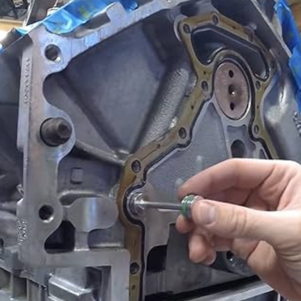 A man installing a billet barbell into a LS engine.