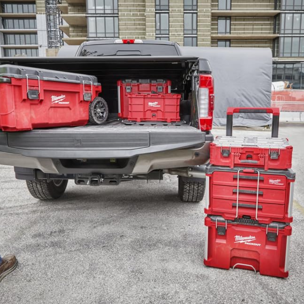 A truck with 3 different Packout rolling boxes, 2 in the bed, and 1 on the ground.