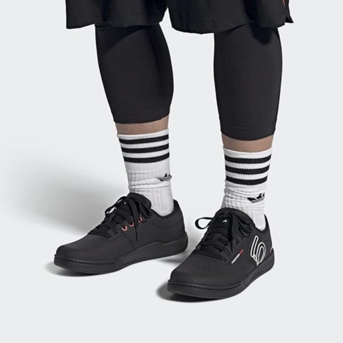 A man wearing platform mountain bike sneakers, black with white and black socks.