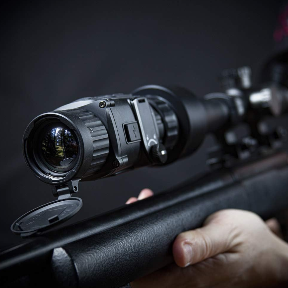 A thermal imaging device clipped on a high powered rifle scope.