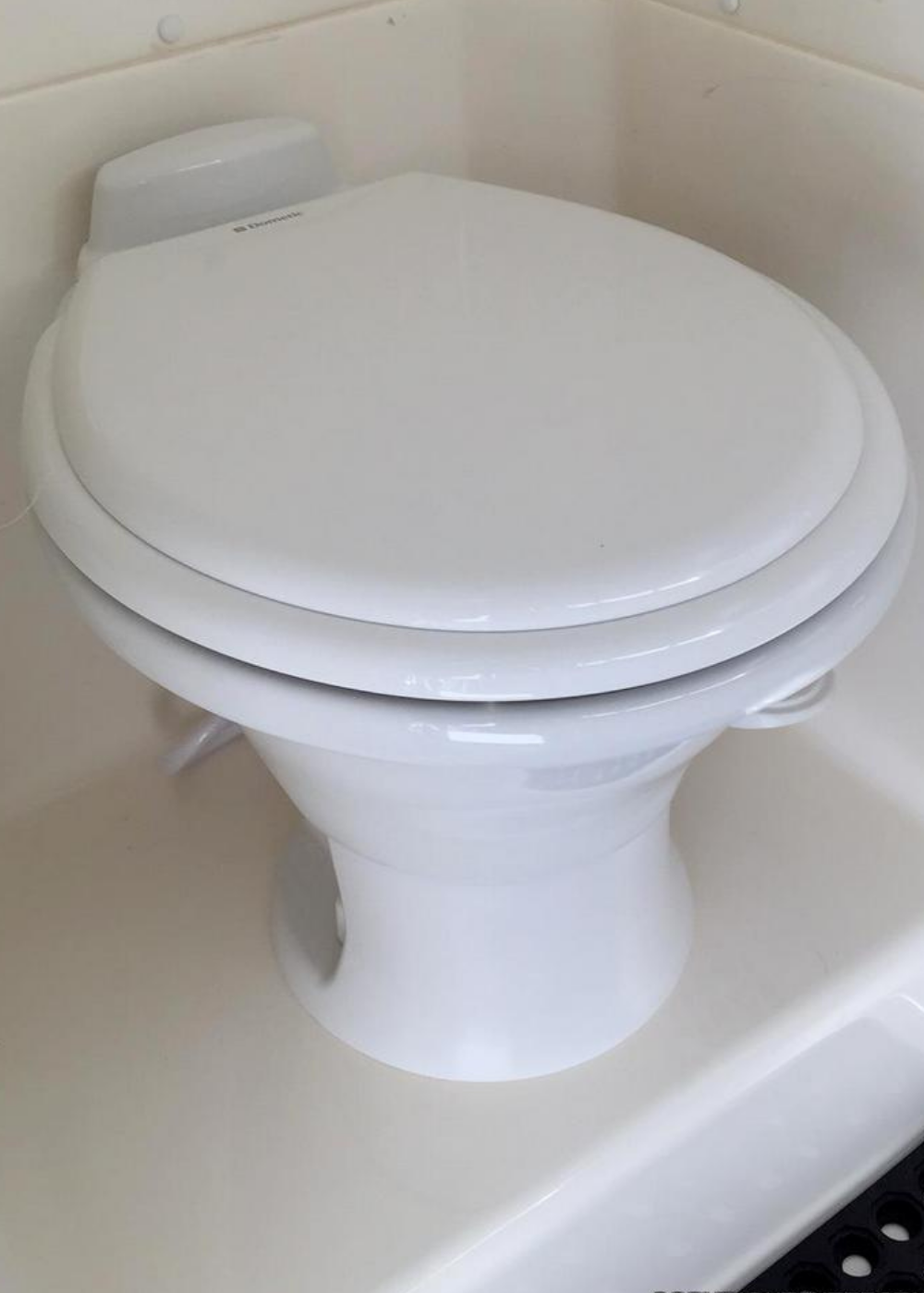 A low profile RV toilet by Dometic installed in an RV.